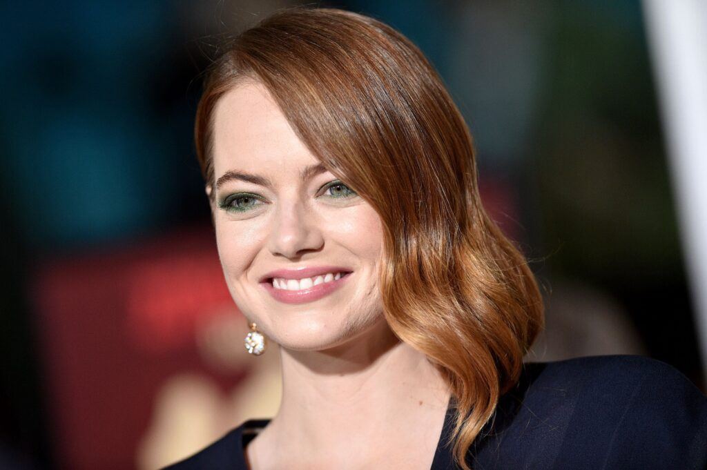 Atriz Emma Stone em evento com cabelo em tons de castanho avermelhado ou acobreado
