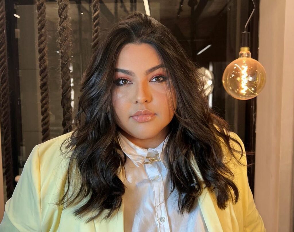 Mulher de blazer amarelo no salão com cabelo em tons de castanho escuro estilo café e chocolate