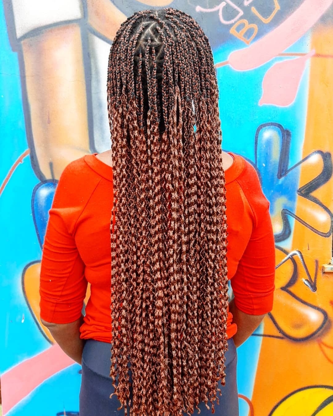 Mulher posa com tranças kanekalon longas ombre cobre em formato miojinho frisadinho