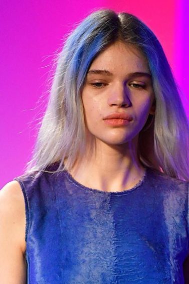 Mulher com cabelos platinados e mechas azuis