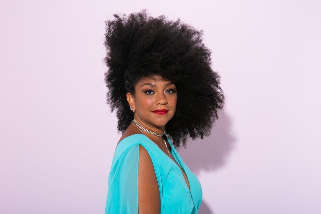 Mulher com penteado lateral no cabelo crespo de frente