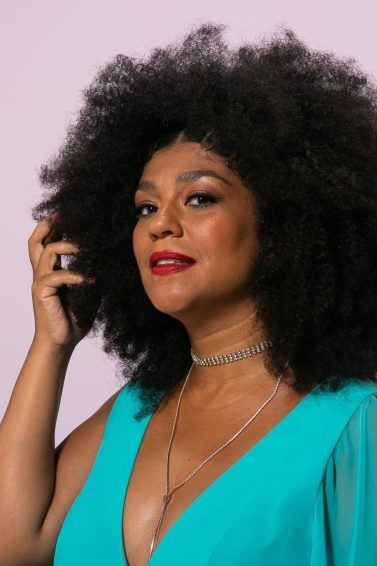 Mulher segurando o cabelo crespo castanho