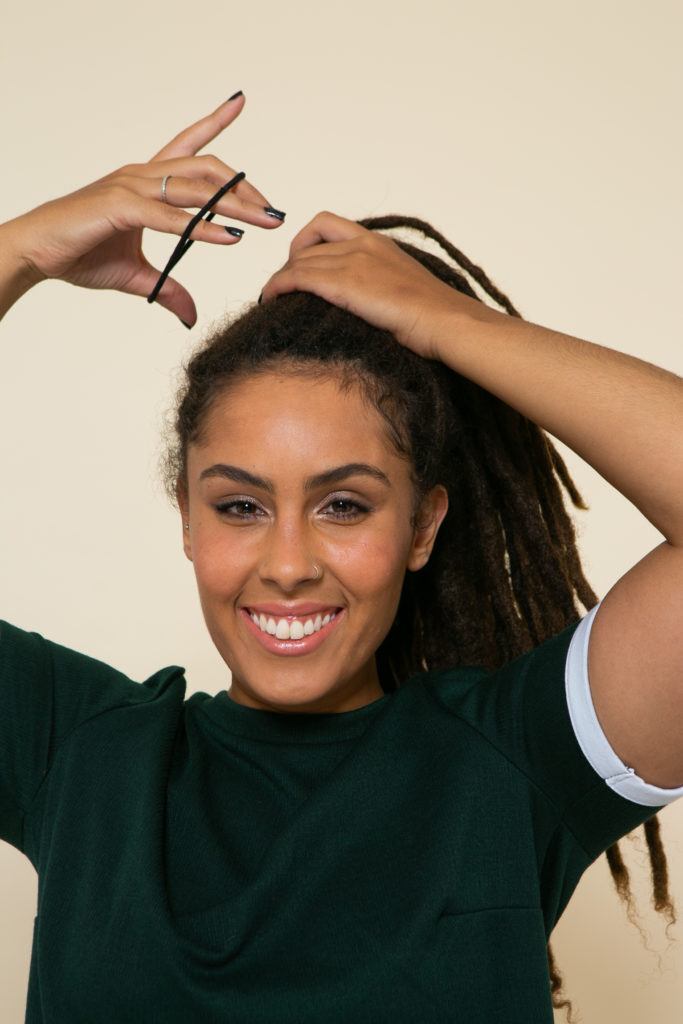 Modelo prende os cabelos com elástico para esilizar os dreadlocks