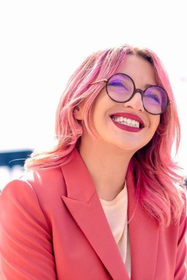 mulher com cabelo rosa médio sorrindo