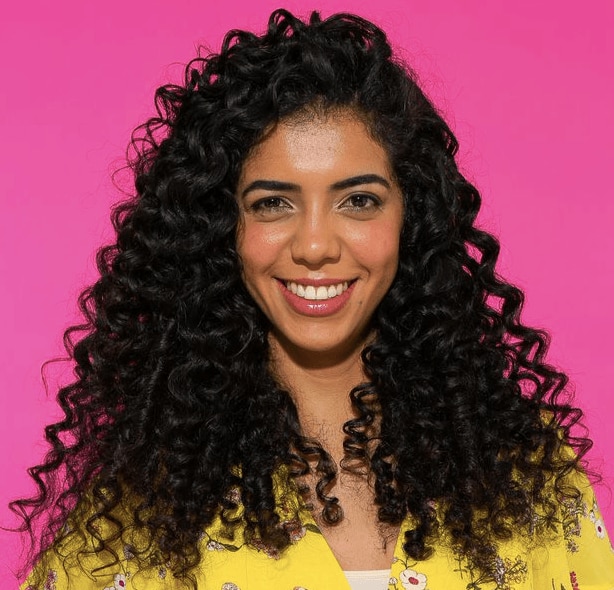 Mulher com cabelo cacheado longo de lado