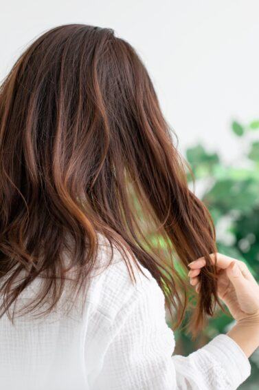 Mulher segurando cabelo ressecado e quebradiço
