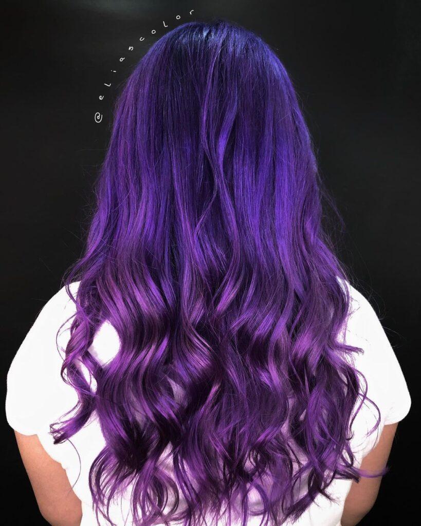 mulher com cabelo roxo longo cacheado