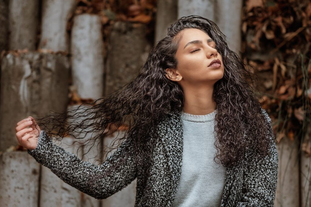 Mulher de cabelo cacheado castanho seco