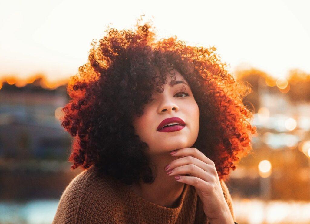 Mulher com cabelo crespo depois de fazer hidronutrição capilar