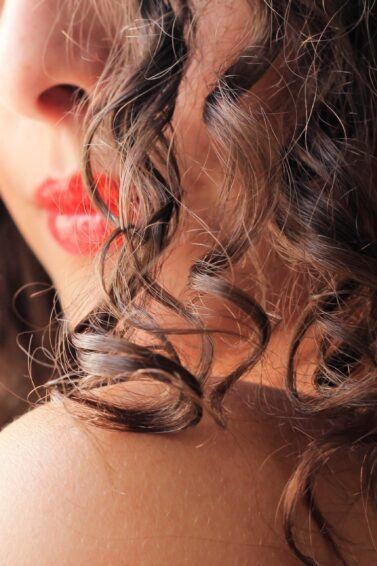 Mulher com cabelo cacheado depois de fazer hidronutrição capilar