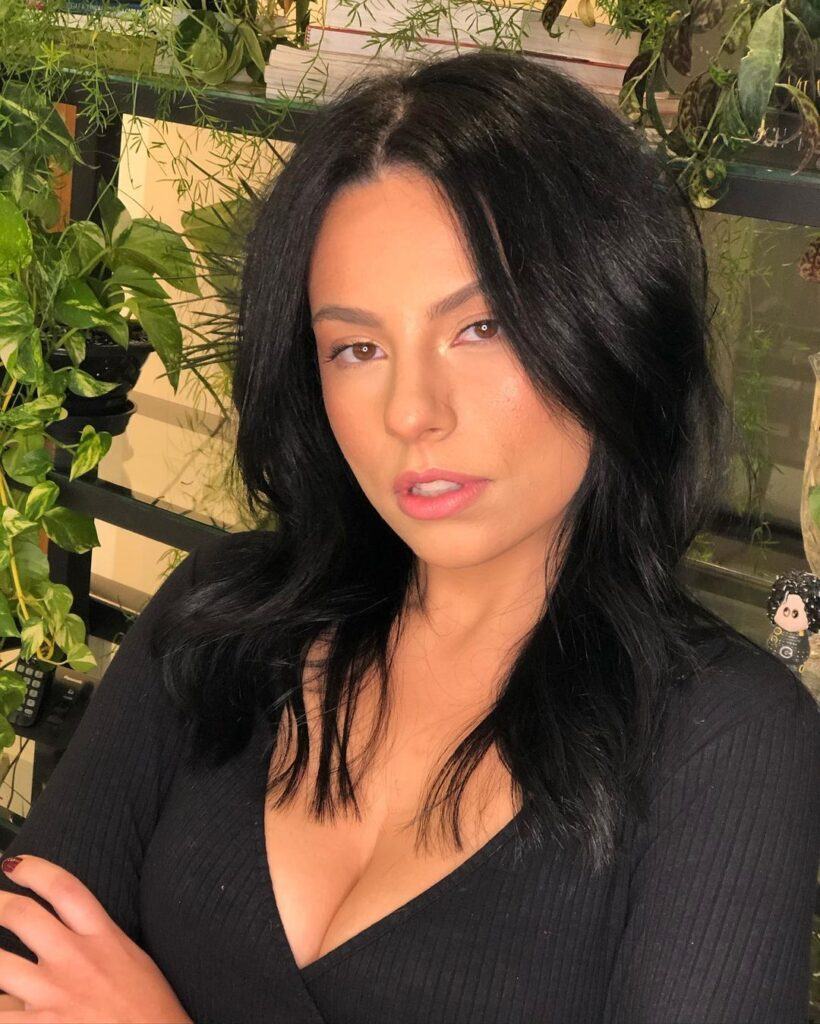 Mulher de blusa preta e cabelo preto médio escuro na paleta de cores inverno profundo