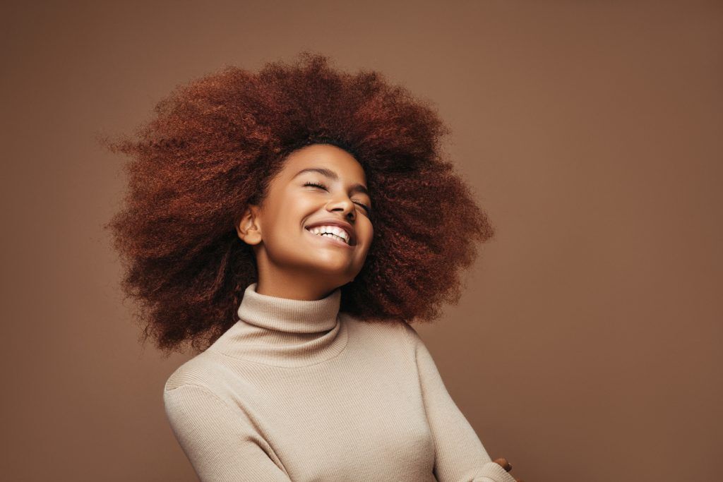 Modelo com cabelo black power em tom avermelhado