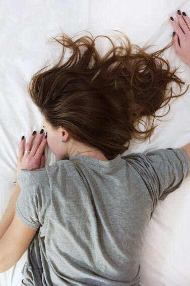 mulher deitada de costas na cama dormindo
