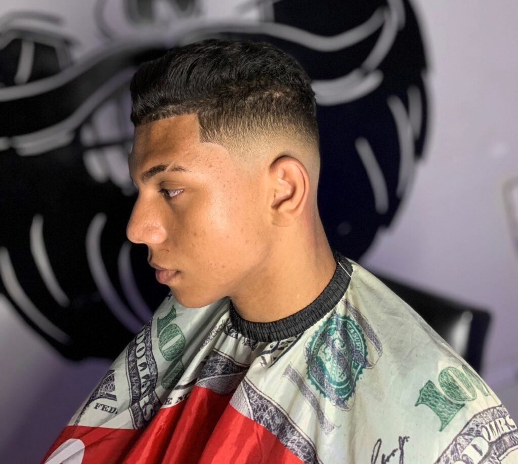 Homem no salão com corte degrade no cabelo estilo low fade