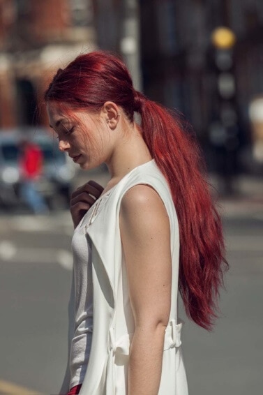 modelo com cabelo preso ruivo com frizz