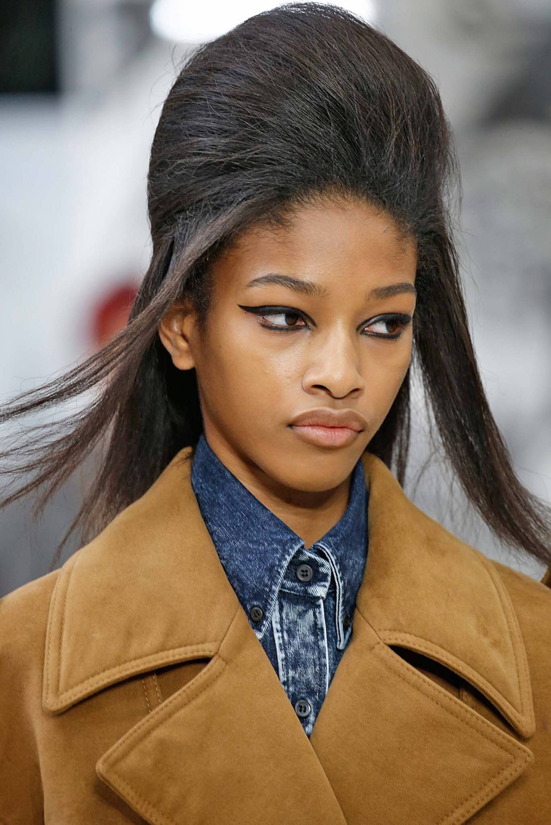 Cabelo crespo alisado com penteado de topete alto