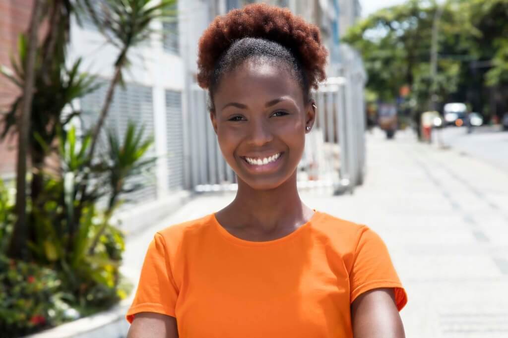 Mulher usa afro puff, um dos penteados afro sugeridos