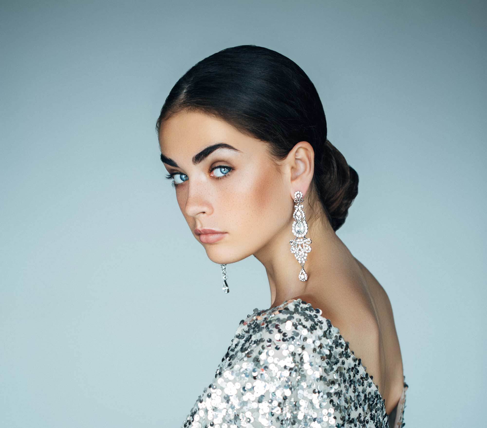 modelo com blusa brilhosa usando um dos penteados para debutantes