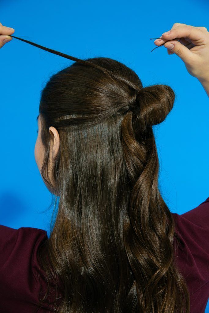 Cabelo liso ondulado sendo finalizado com coque semi preso 