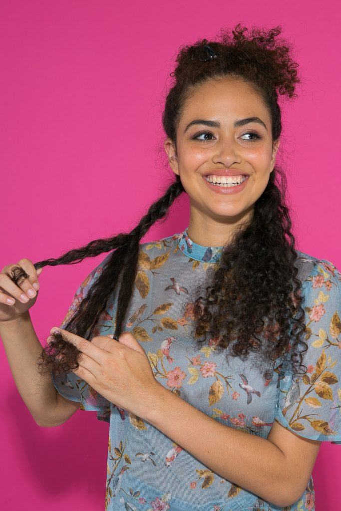 cabelo cacheado longo sendo trançado na parte inferior