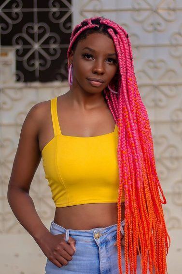 Mulher com box braids rosa no cabelo longo
