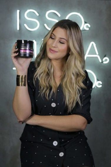 Niina Secrets segura produto de TRESemmé para matéria de workshops tresemmé