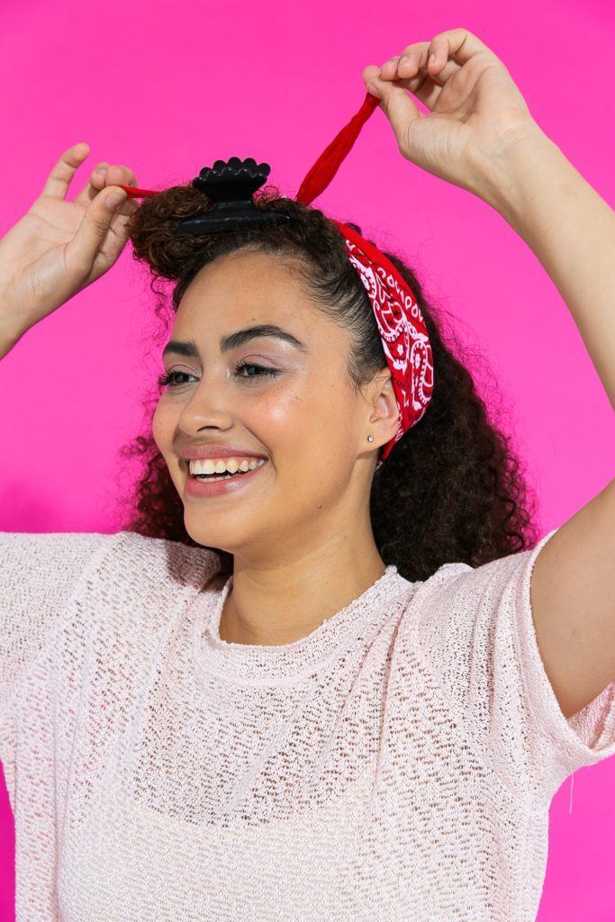 Cabelo cacheado sendo amarrado com lenço