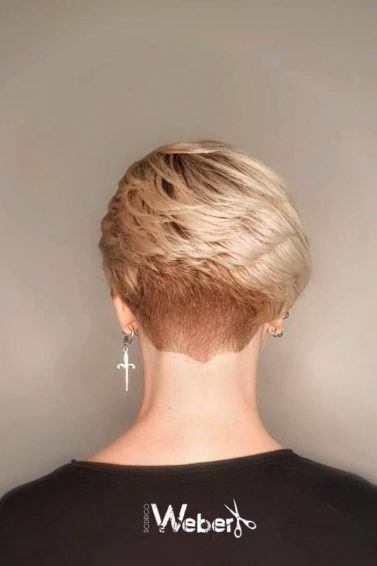 Mulher com cabelo curto loiro raspado na nuca