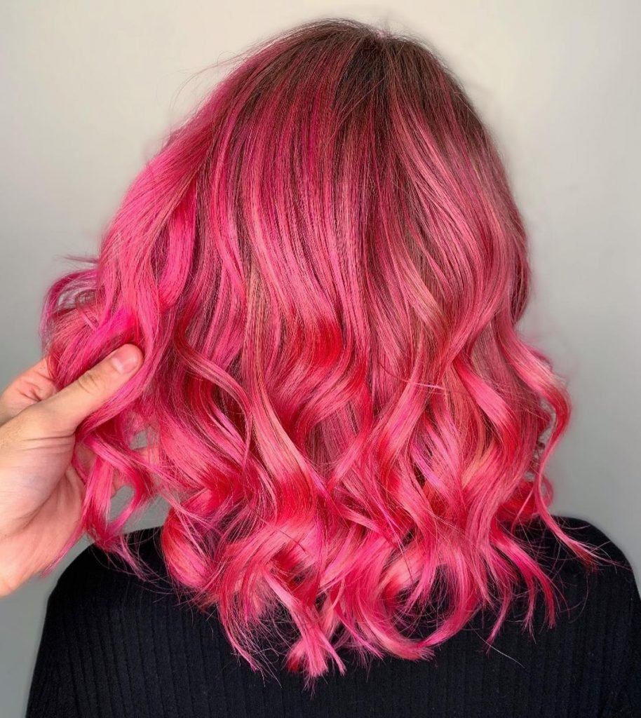 mulher com cabelo rosa ondulado