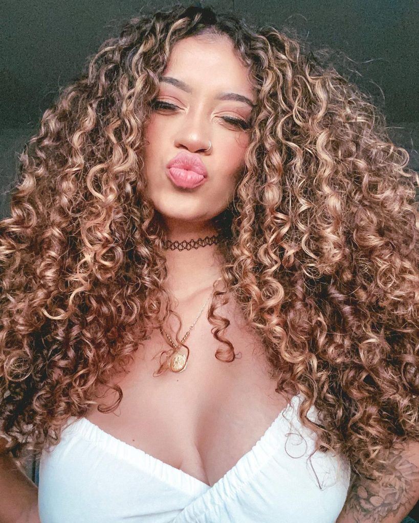 mulher com cabelo morena iluminada cacheado