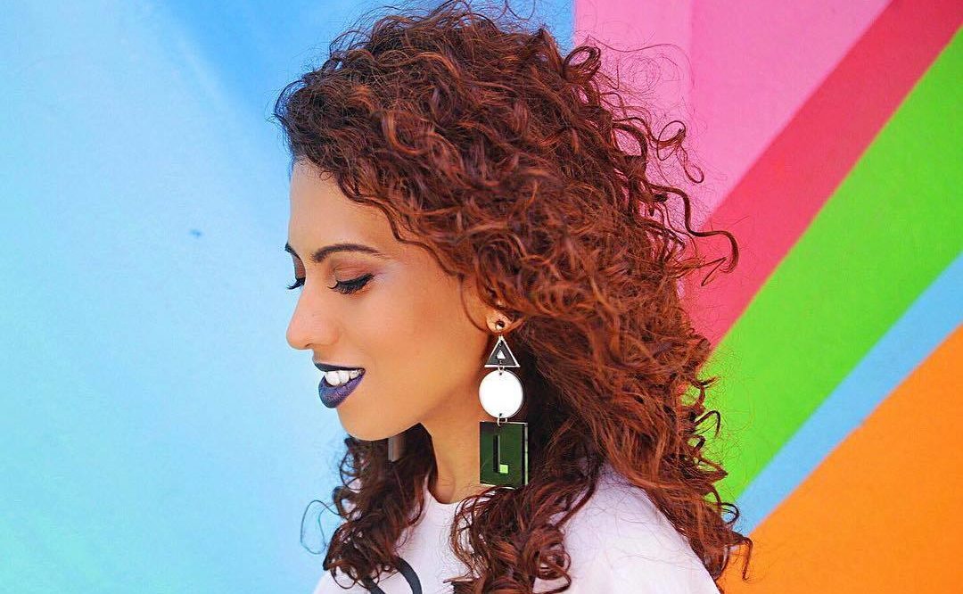 Carla Lemos com cabelos ruivos e cacheados