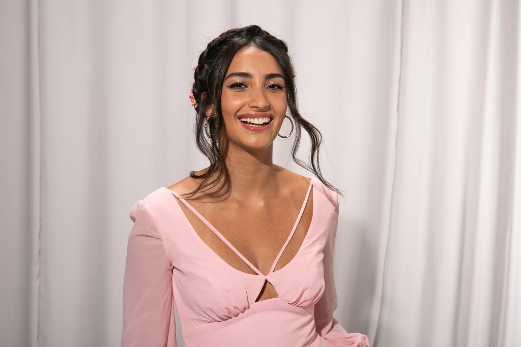 mulher sorrindo com cabelo preso e mechas soltas