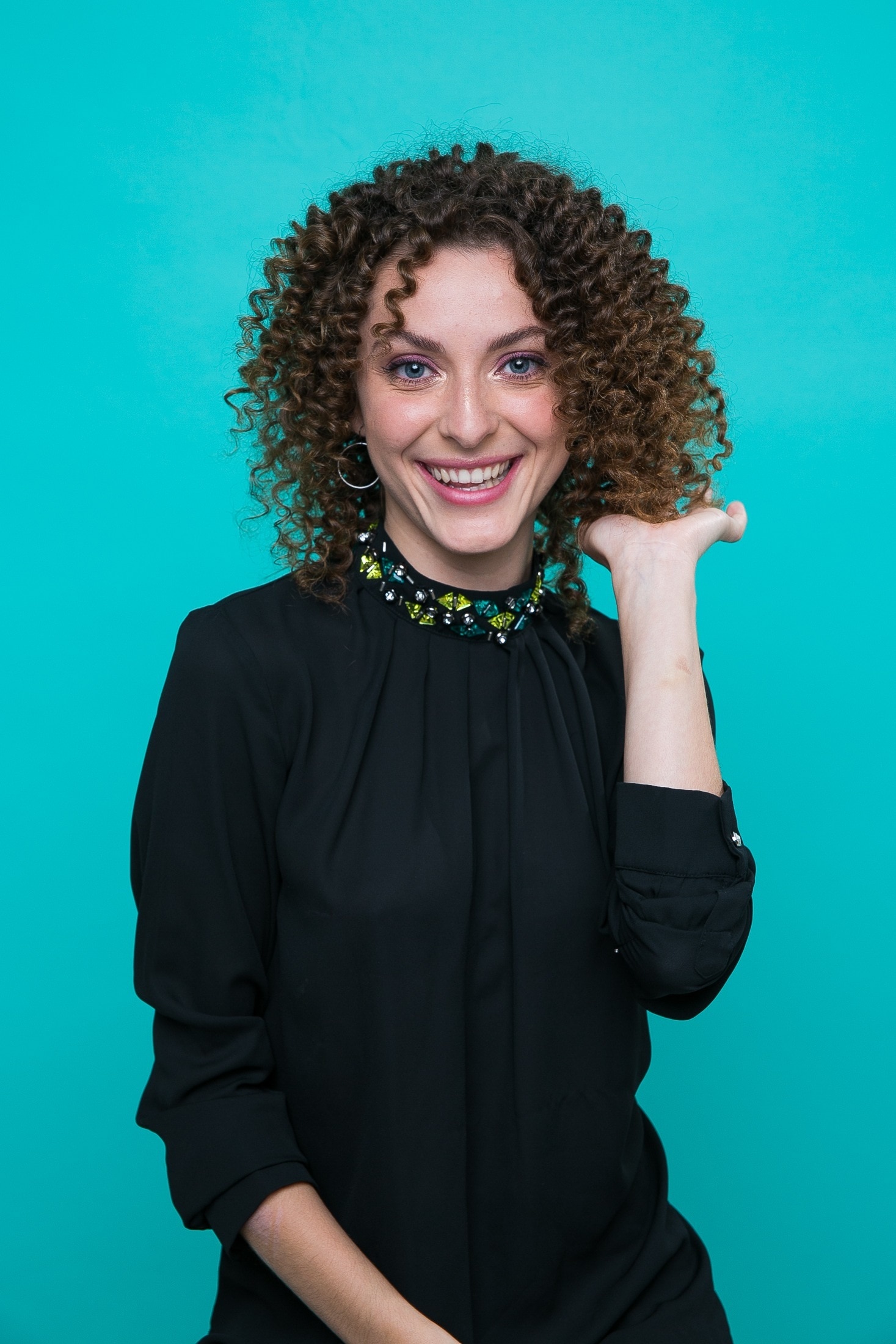 Mulher om cabelo curto cacheado dividido ao meio