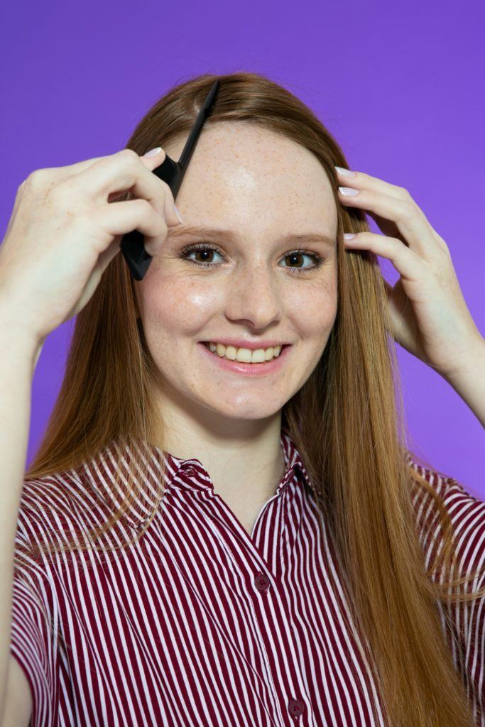 modelo de cabelo longo repartindo o cabelo com pente fino