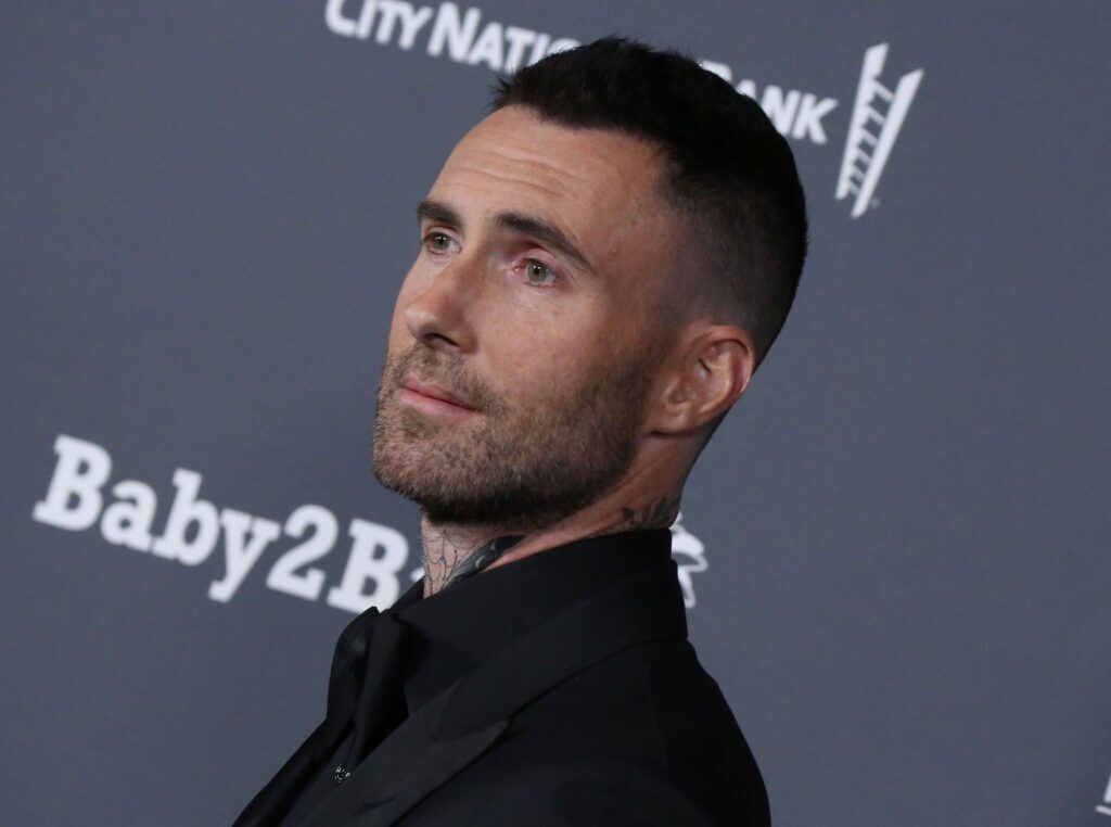 Cantor Adam Levine num evento com roupa preta e corte degrade no cabelo