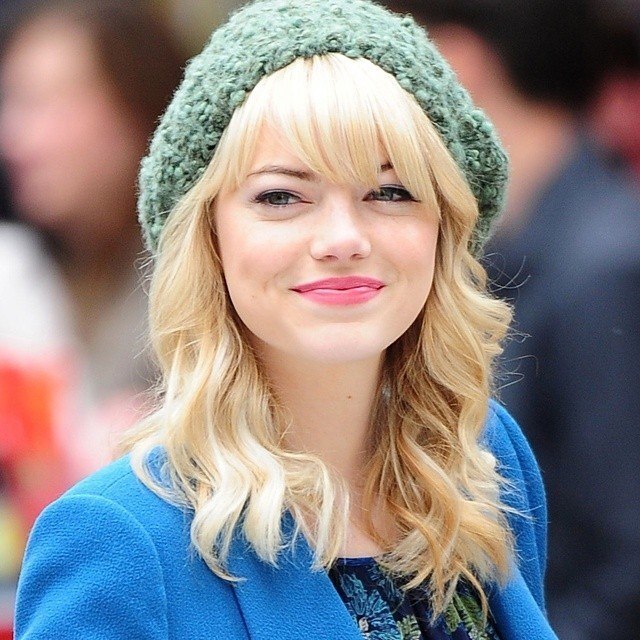 Emma Stone com franja lateral desfiada para rosto redondo