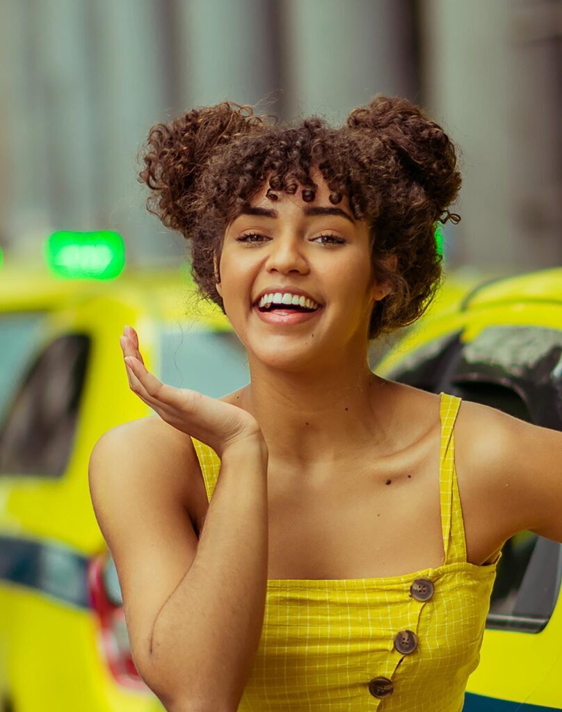 coque lateral space buns em cabelo com franja cacheada