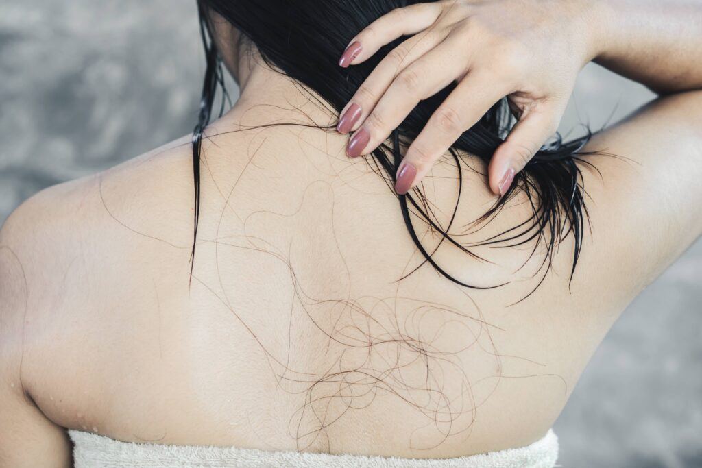 Mulher no banho para como lavar o cabelo com queda