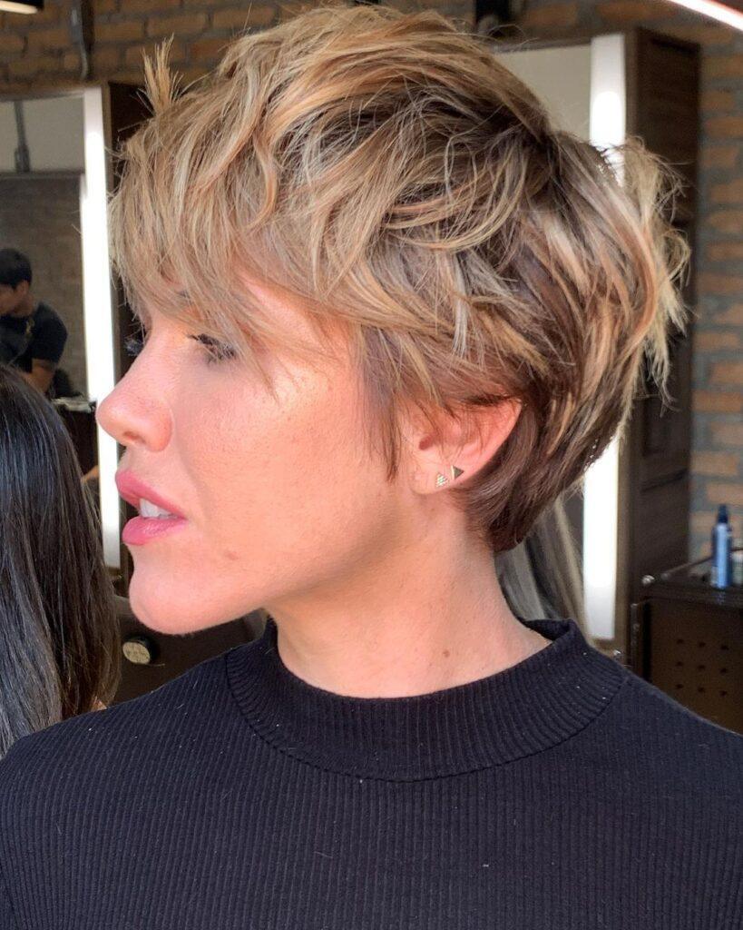 mulher de lado mostra corte pixie com franja longa