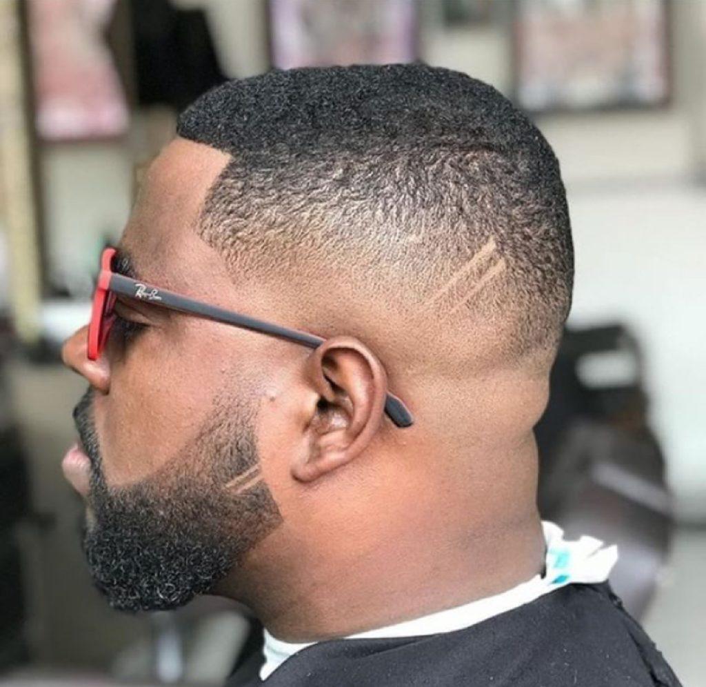 Homem com cabelo curto degradê crespo e óculos escuros
