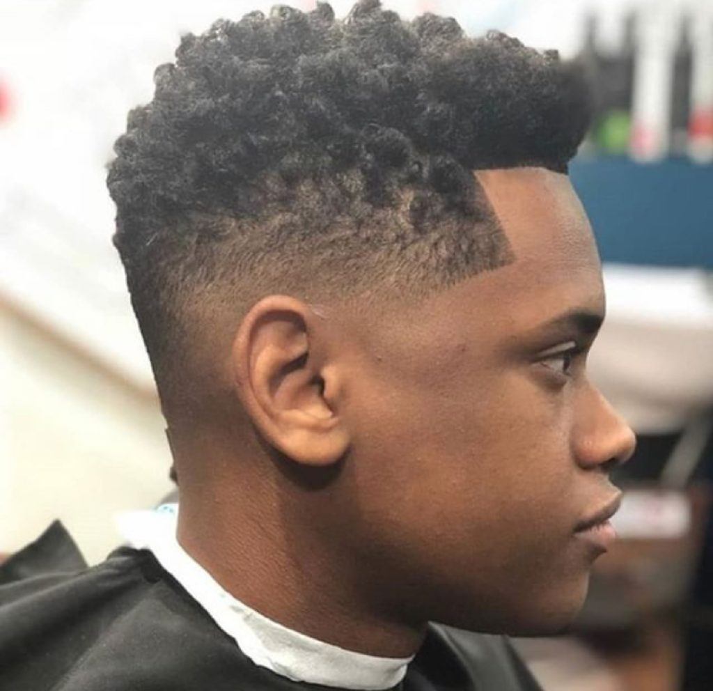Homem com cabelo curto crespo com corte degradê e nudred