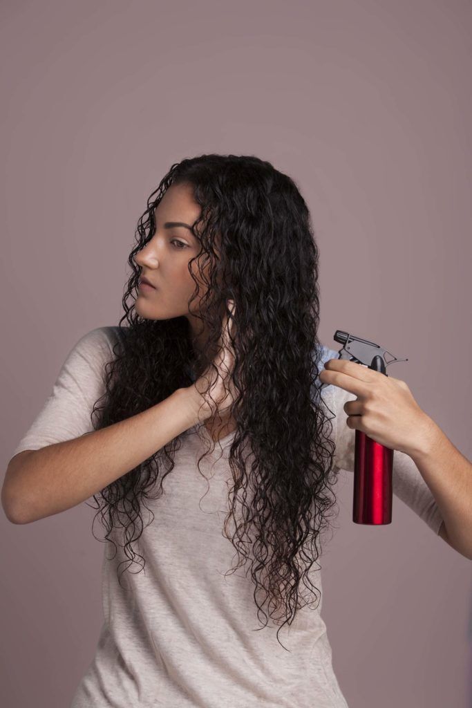 Mulher com cabelos cacheados e molhados
