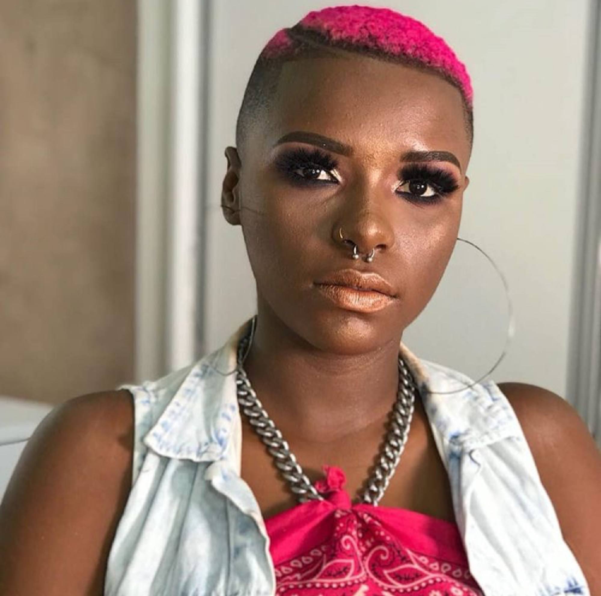 Nathália Caetano com cabelo crespo rosa e curto