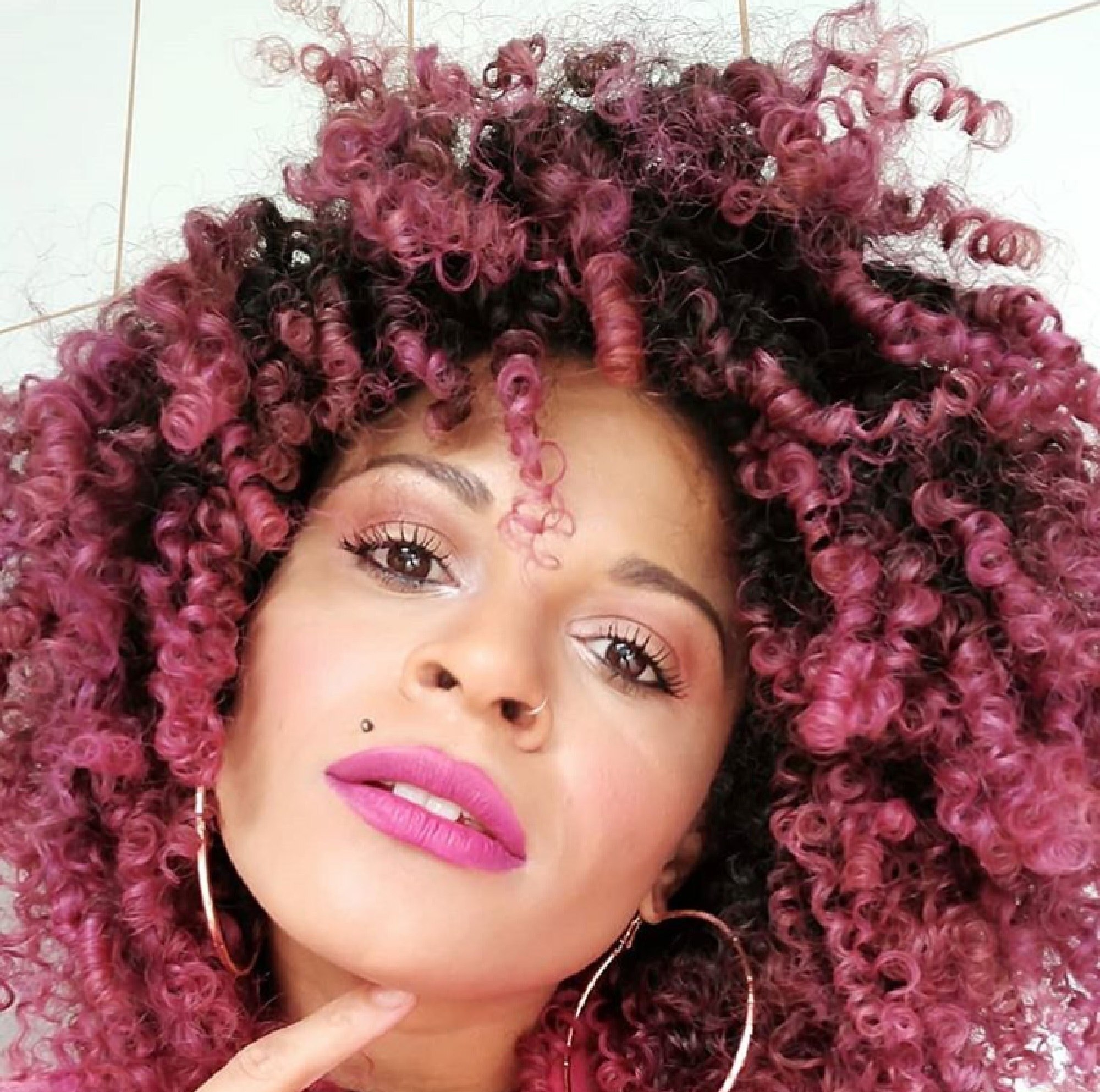 Dalila Flor com cabelo cacheado rosa