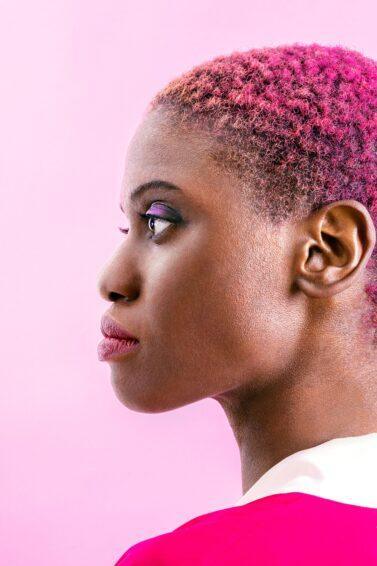 mulher de cabelo rosa crespo