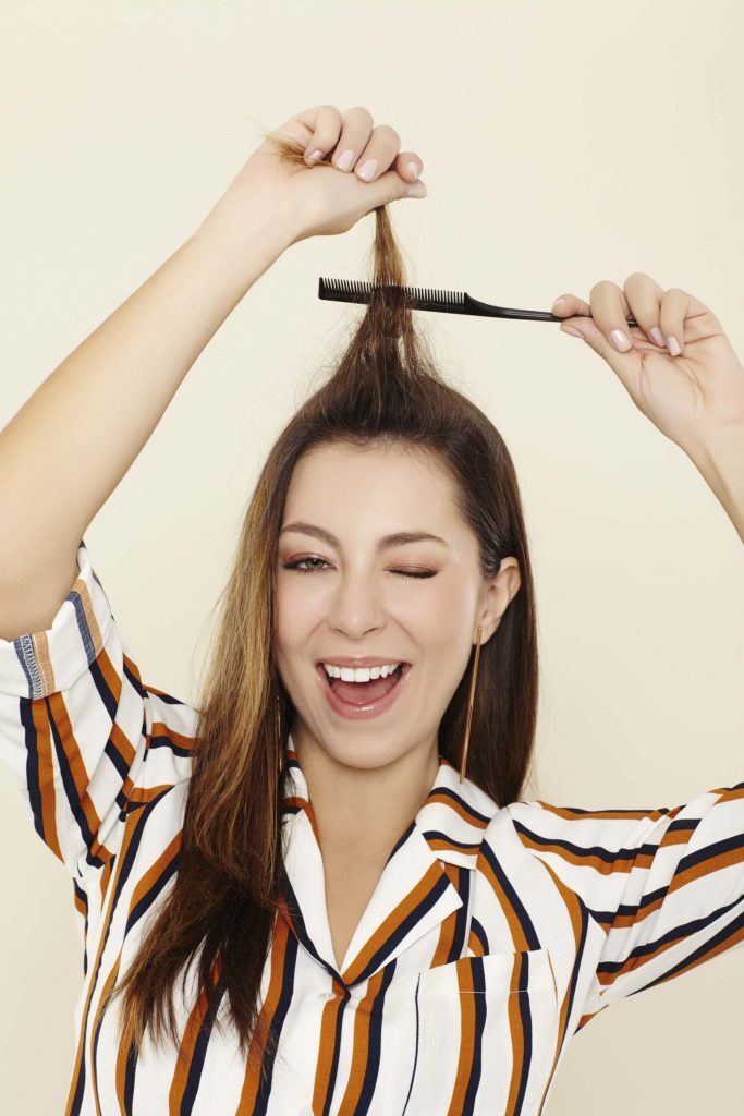 mulher com cabelo castanho longo ilustrando a matéria sobre desfiar a raiz