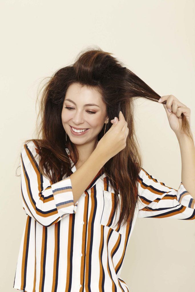 mulher com cabelo castanho longo ilustrando a matéria sobre desfiar a raiz