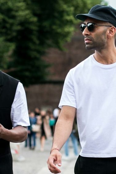 Dois homens usam bonés na rua