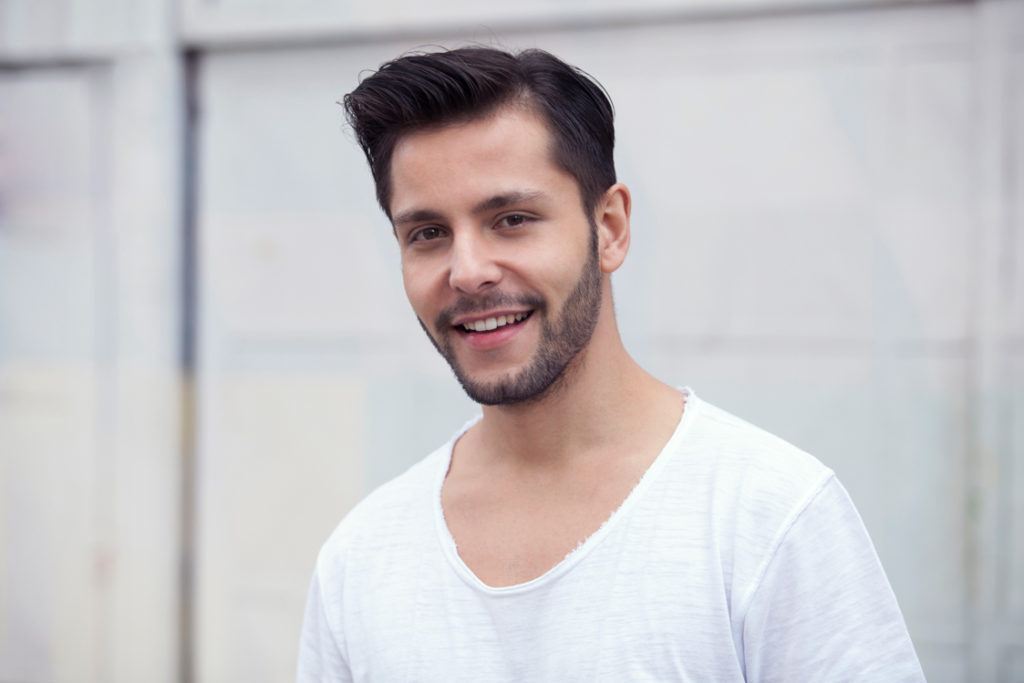 Modelo usa cabelo com topete de lado e efeito seco