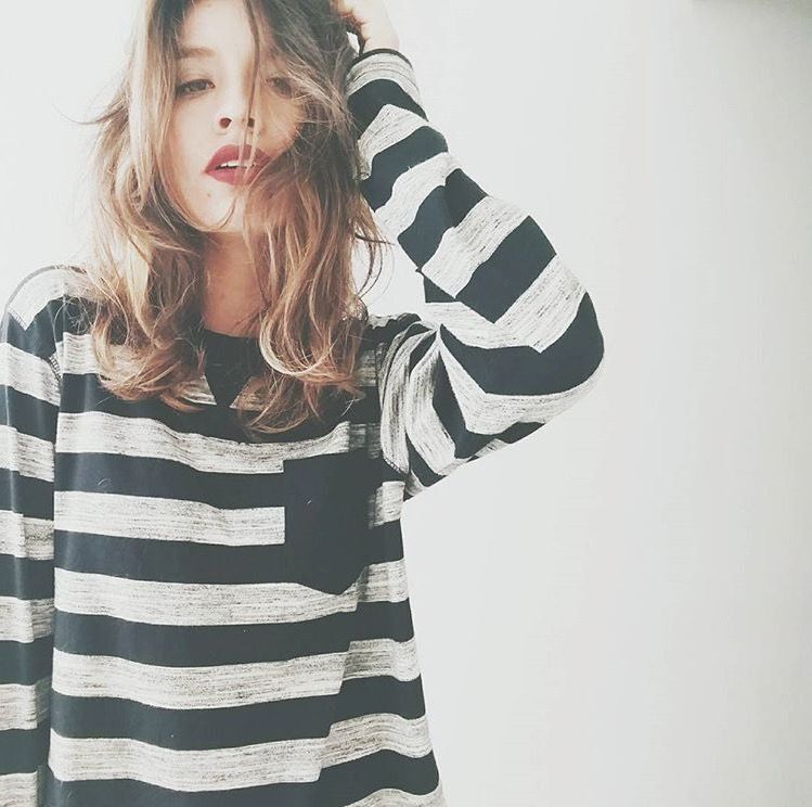 Isadora Ribeiro usa cabelo médio e blusa listrada